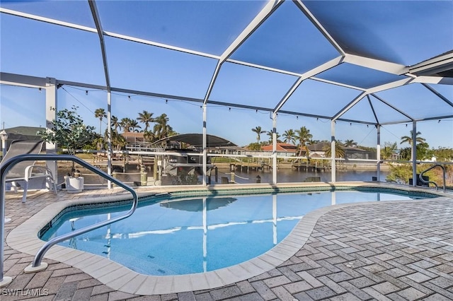 view of swimming pool with a lanai, a patio area, and a water view