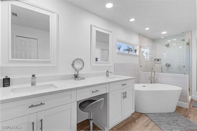 bathroom featuring vanity, wood-type flooring, and shower with separate bathtub