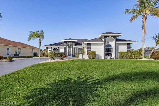 view of front of home with cooling unit and a front lawn