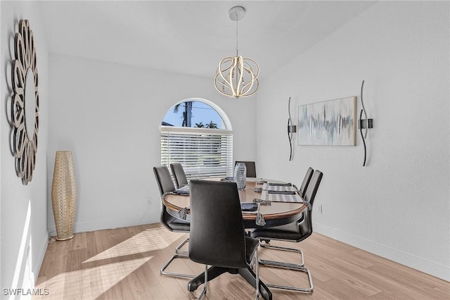 dining area featuring light hardwood / wood-style flooring, vaulted ceiling, and a notable chandelier