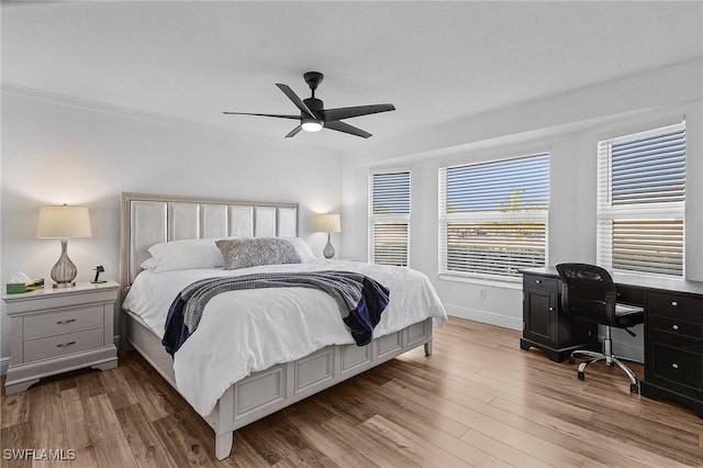 bedroom featuring ceiling fan, light hardwood / wood-style flooring, and ornamental molding