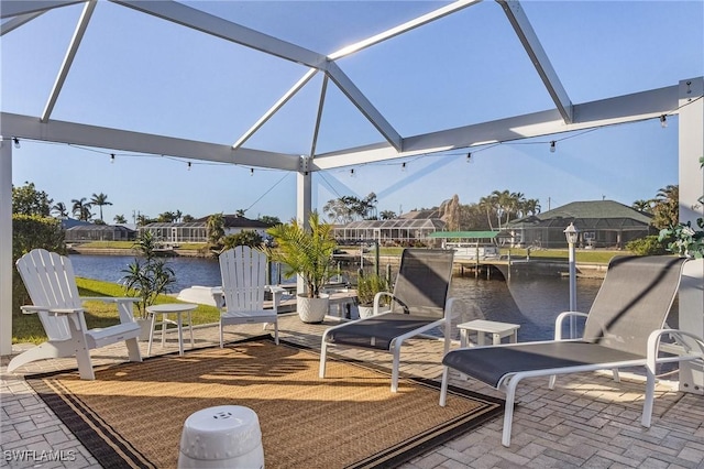 view of patio / terrace featuring a water view and a lanai