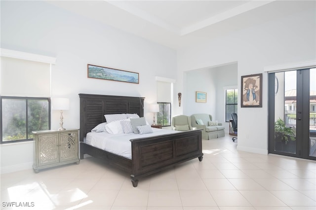 tiled bedroom featuring a high ceiling, access to outside, and multiple windows