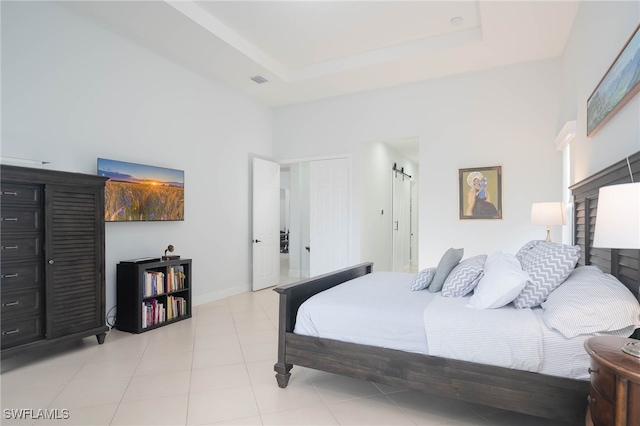 bedroom featuring a raised ceiling and light tile patterned flooring