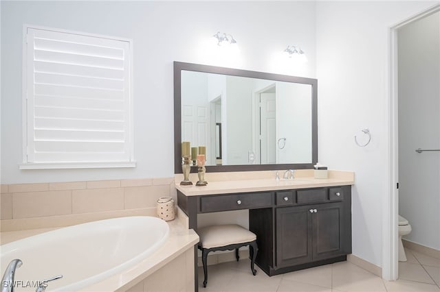 bathroom with tiled bath, tile patterned flooring, vanity, and toilet