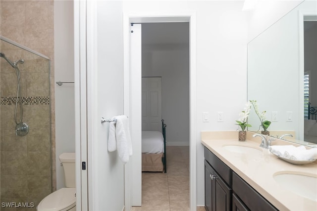 bathroom with tile patterned floors, vanity, toilet, and tiled shower