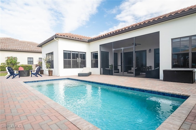 view of pool with a fire pit, ceiling fan, and a patio