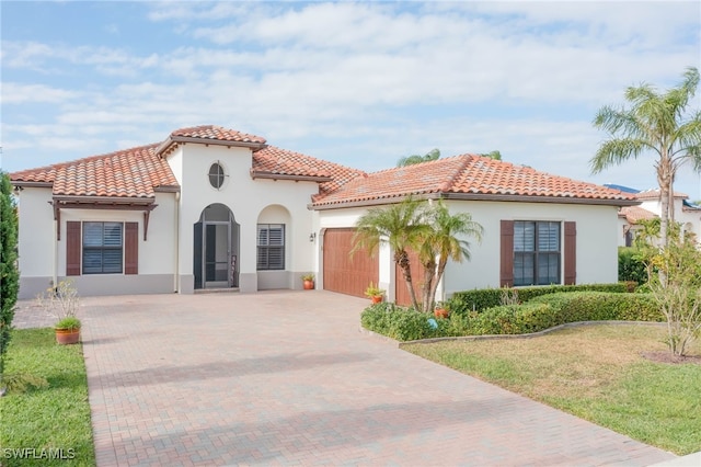 mediterranean / spanish home featuring a garage