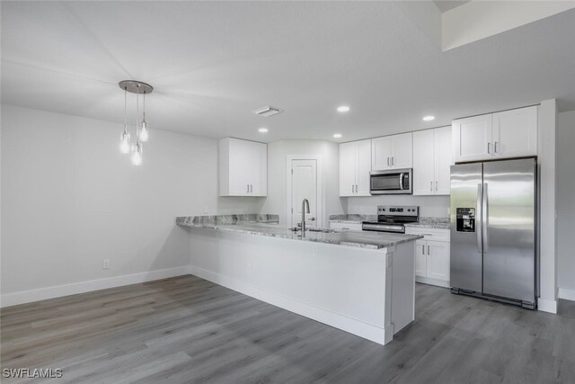 kitchen with decorative light fixtures, white cabinetry, appliances with stainless steel finishes, and kitchen peninsula