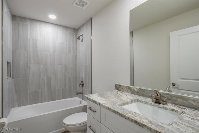 full bathroom with tiled shower / bath combo, toilet, and vanity