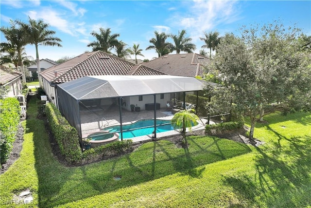 view of swimming pool with a lawn, a patio area, a lanai, and an in ground hot tub