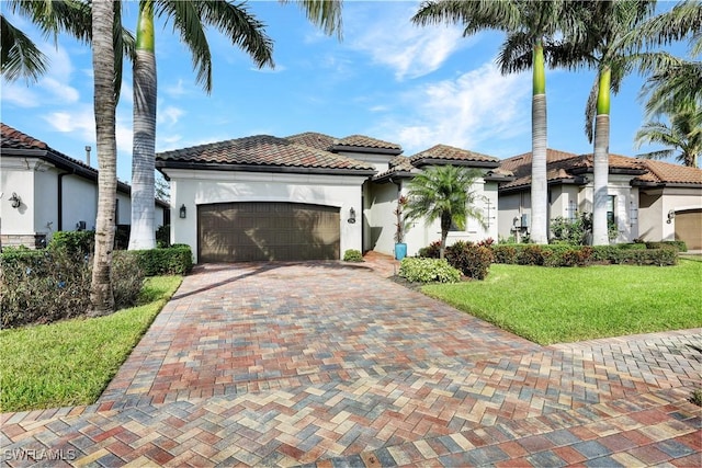 mediterranean / spanish-style home featuring a front lawn and a garage