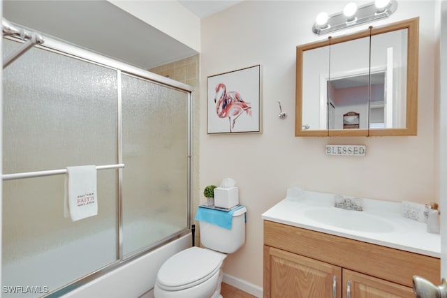 full bathroom featuring vanity, bath / shower combo with glass door, and toilet