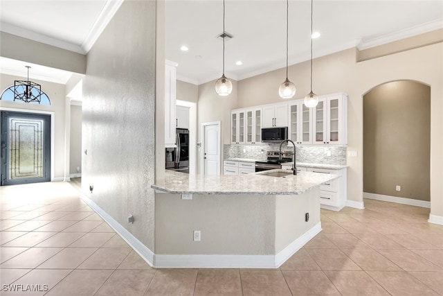 kitchen featuring light stone countertops, decorative light fixtures, decorative backsplash, white cabinets, and appliances with stainless steel finishes