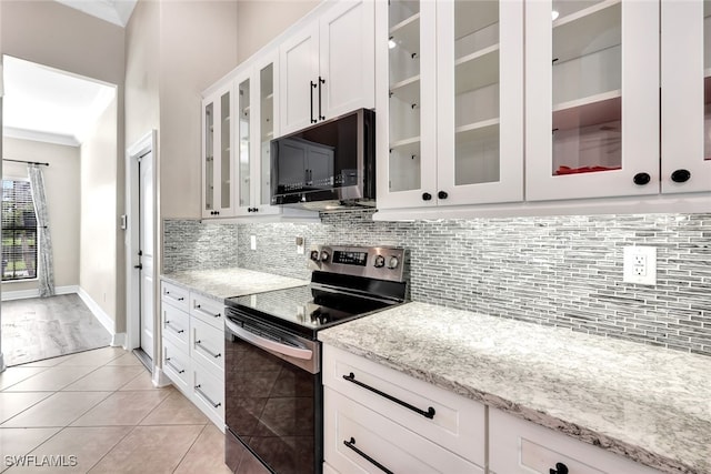 kitchen featuring light stone countertops, tasteful backsplash, light tile patterned flooring, white cabinetry, and stainless steel appliances