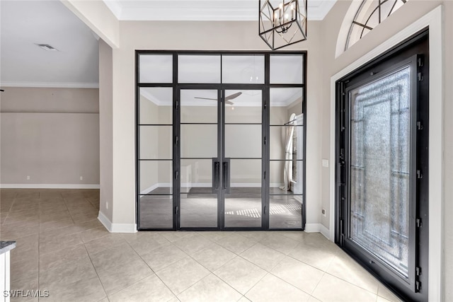 foyer entrance with light tile patterned flooring, ceiling fan with notable chandelier, and ornamental molding