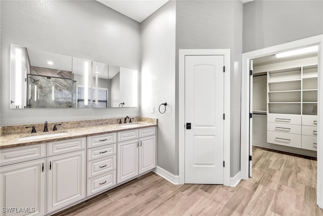 bathroom featuring hardwood / wood-style flooring, vanity, and walk in shower