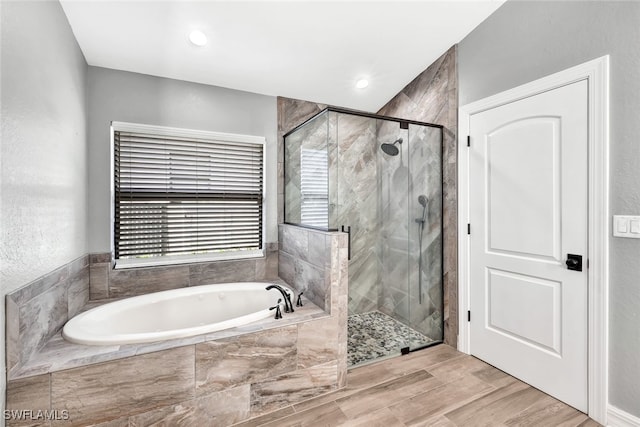 bathroom featuring hardwood / wood-style flooring and shower with separate bathtub