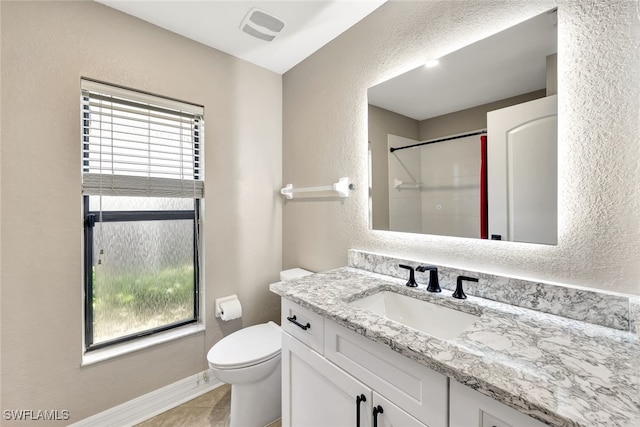 bathroom featuring tile patterned floors, toilet, a shower, and vanity