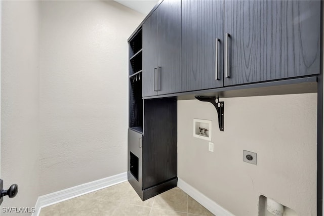 clothes washing area with hookup for an electric dryer, cabinets, light tile patterned floors, and washer hookup