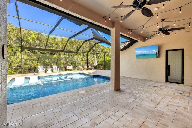 view of swimming pool featuring ceiling fan, a lanai, and a patio