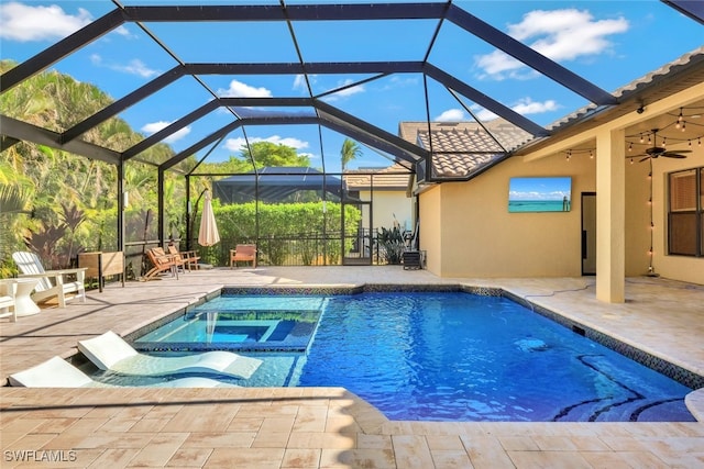 view of swimming pool featuring glass enclosure, an in ground hot tub, ceiling fan, and a patio