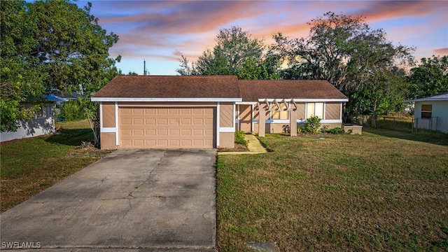 single story home with a lawn and a garage