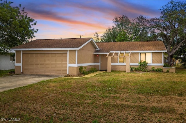 ranch-style house with a yard and a garage