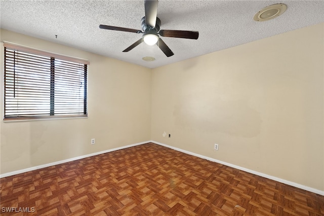 unfurnished room with ceiling fan, dark parquet flooring, and a textured ceiling