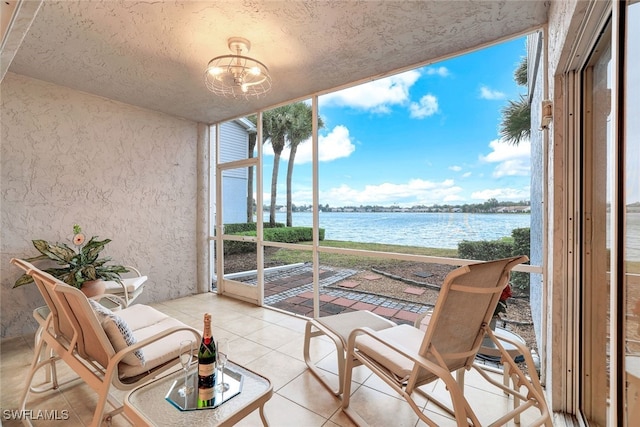 sunroom with a water view and a notable chandelier