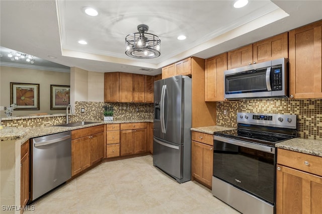 kitchen with backsplash, stainless steel appliances, a tray ceiling, and sink