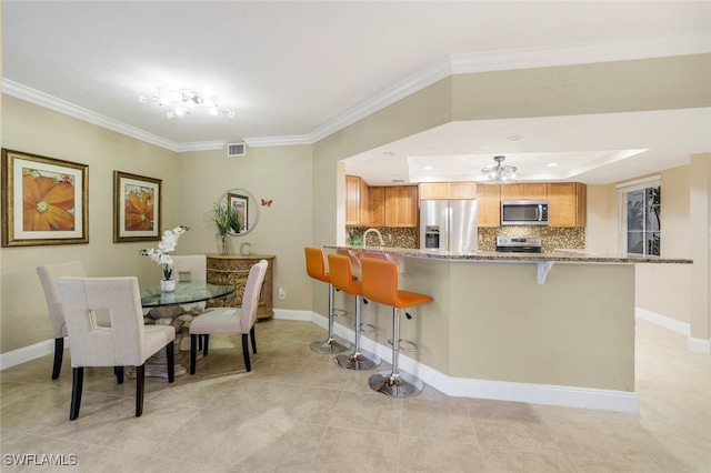 tiled dining room featuring crown molding