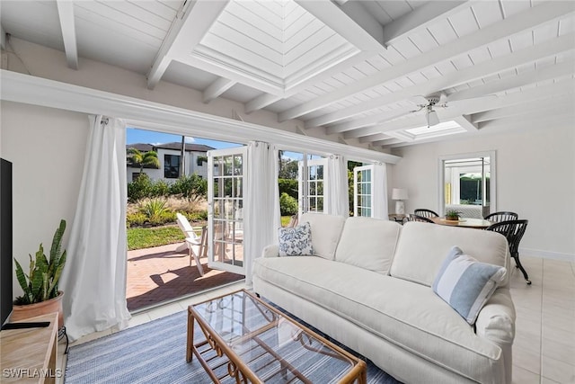 tiled living room with a wealth of natural light, beamed ceiling, and ceiling fan