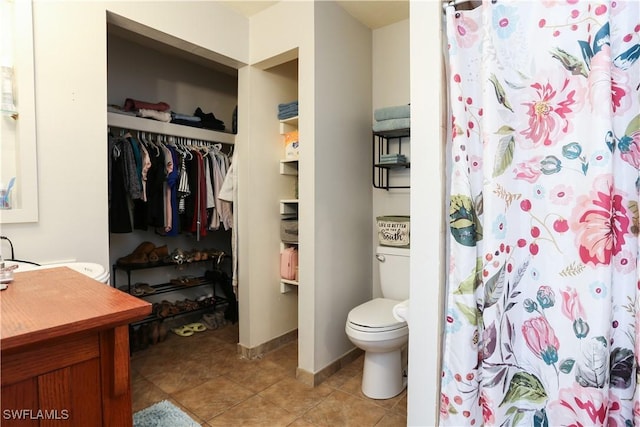 bathroom featuring tile patterned floors, walk in shower, vanity, and toilet