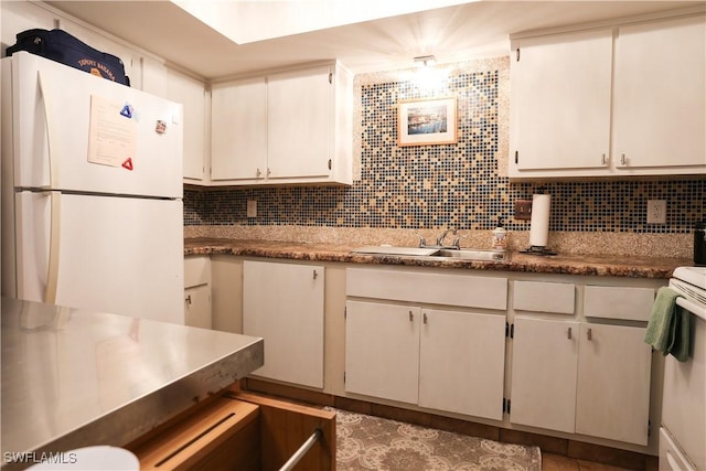 kitchen with decorative backsplash, white appliances, white cabinetry, and sink