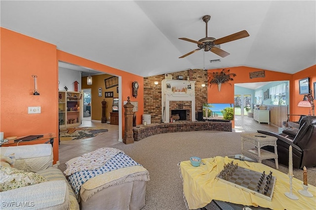 tiled living room featuring ceiling fan, a fireplace, brick wall, and lofted ceiling