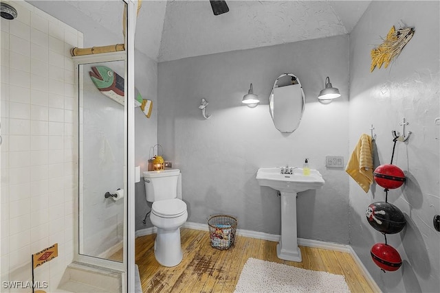 bathroom featuring walk in shower, a textured ceiling, vaulted ceiling, hardwood / wood-style floors, and toilet