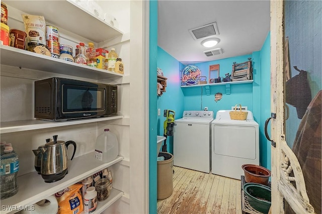 laundry room with light hardwood / wood-style floors and separate washer and dryer