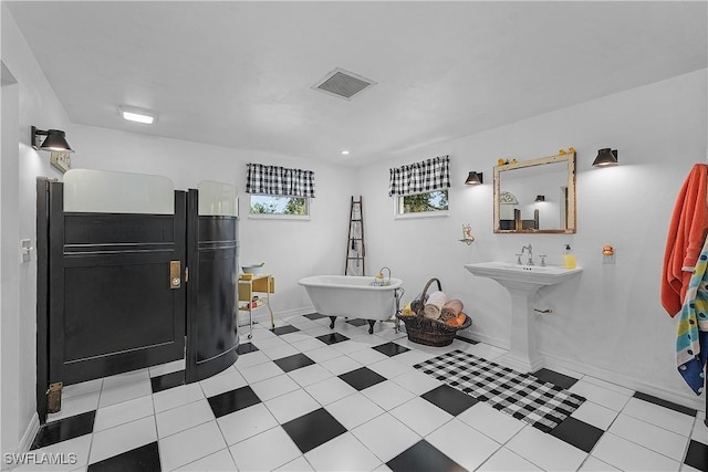 bathroom featuring tile patterned flooring and a tub to relax in