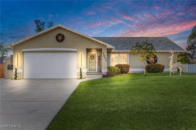 ranch-style house with a yard and a garage