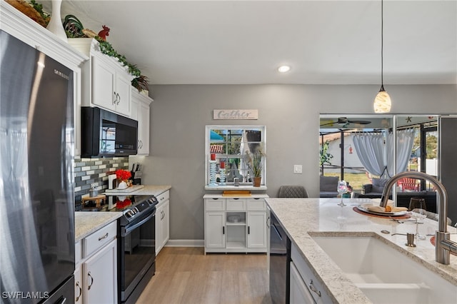 kitchen featuring sink, white cabinetry, black appliances, pendant lighting, and backsplash