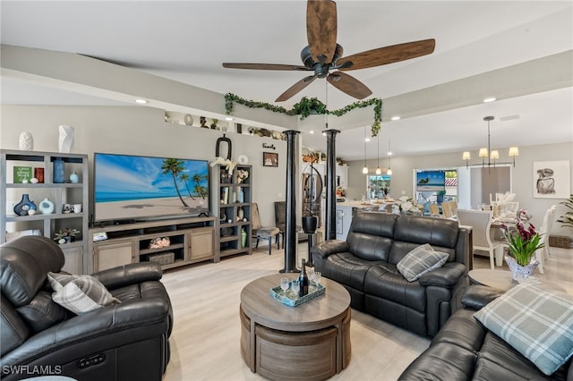 living room with ceiling fan with notable chandelier and light hardwood / wood-style floors