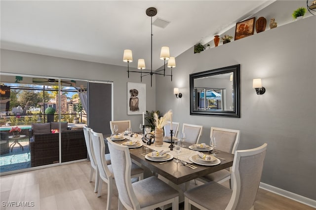 dining room with hardwood / wood-style flooring and a chandelier