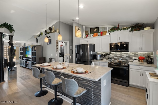 kitchen with range with electric cooktop, black fridge, pendant lighting, and white cabinets