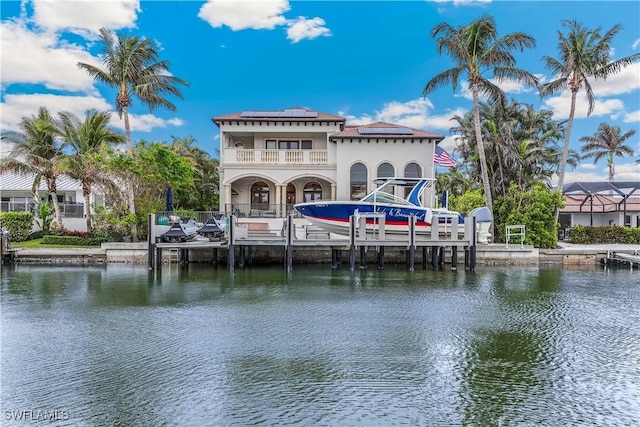 dock area with a balcony and a water view