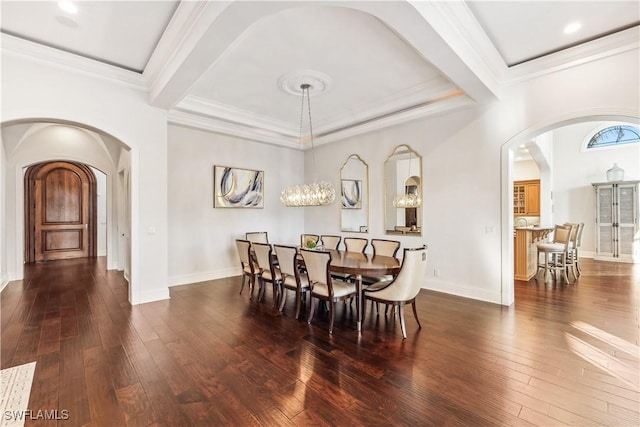 dining room with dark hardwood / wood-style floors, crown molding, and an inviting chandelier