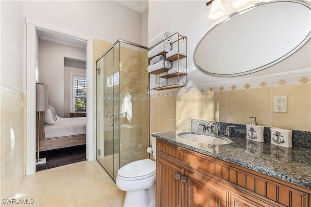 bathroom with tile patterned flooring, vanity, toilet, and tile walls