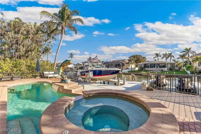 view of swimming pool with a water view, an in ground hot tub, and a dock