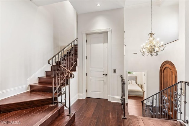 foyer entrance with a chandelier, a high ceiling, and dark hardwood / wood-style flooring