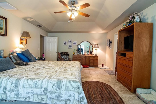 tiled bedroom featuring a raised ceiling and ceiling fan